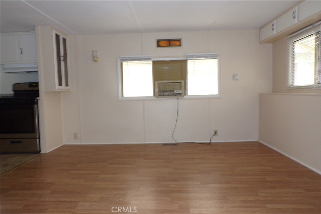 12710 3rd Street, Unit 57 Yucaipa, CA 92399 - Photo 5 of 13 an empty room with wooden floor and windows