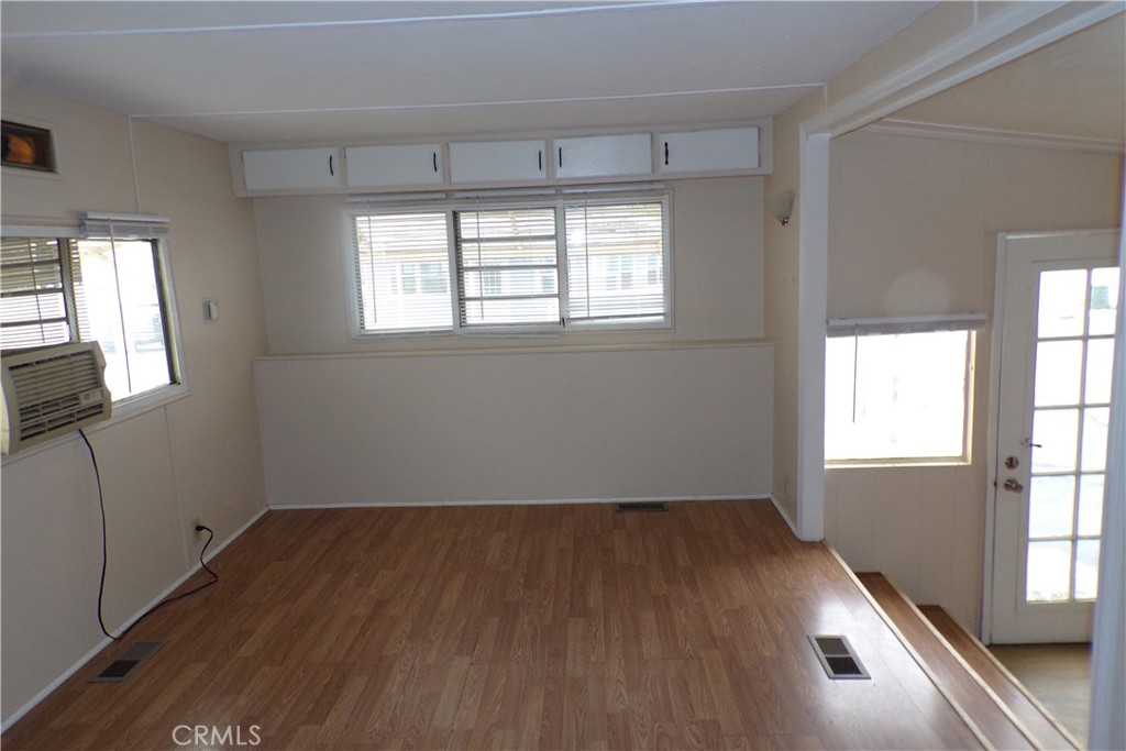 12710 3rd Street, Unit 57 Yucaipa, CA 92399 - Photo 6 of 13 an empty room with wooden floor and windows