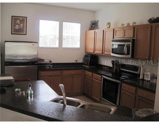 7351 Millstone Street Windermere, FL 34786 - Photo 3 of 15 a kitchen with a sink appliances and cabinets