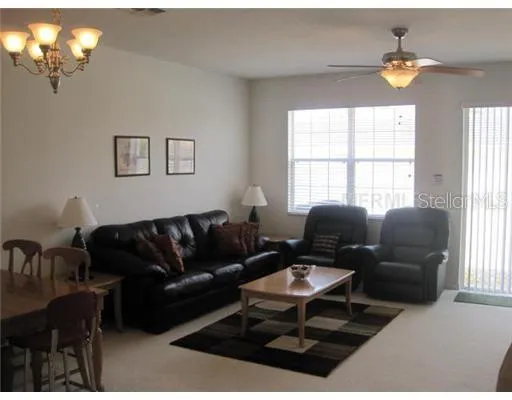 a living room with furniture a chandelier and a window
