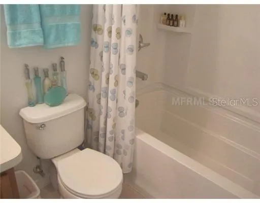 a white toilet sitting next to a bath tub and a shower