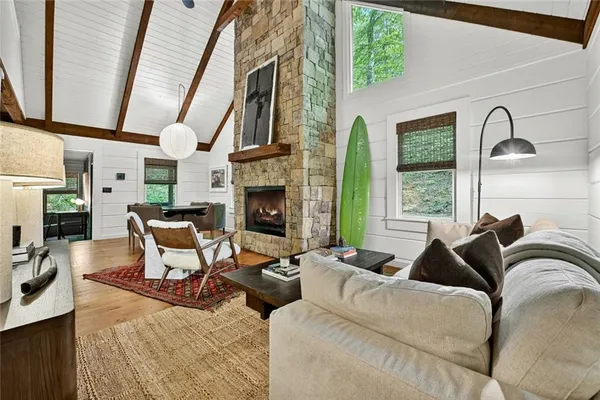 a living room with furniture fireplace and a large window