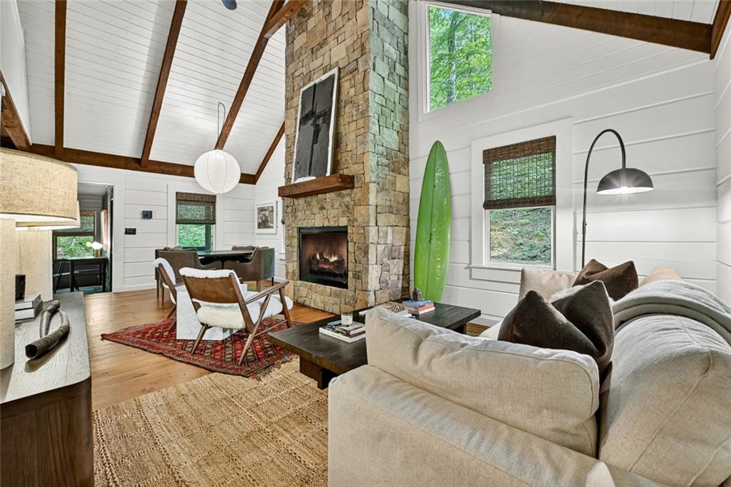 a living room with furniture fireplace and a large window