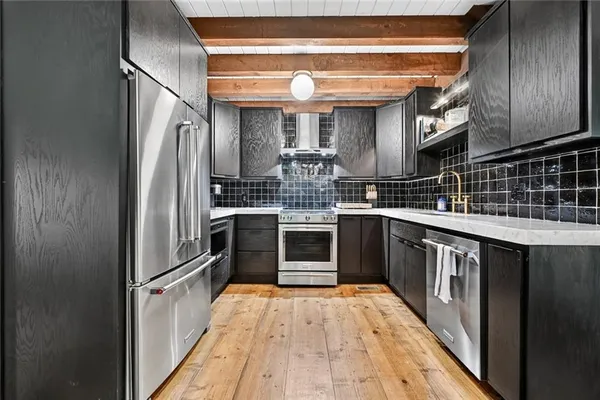 a kitchen with stainless steel appliances granite countertop a refrigerator a stove and a sink