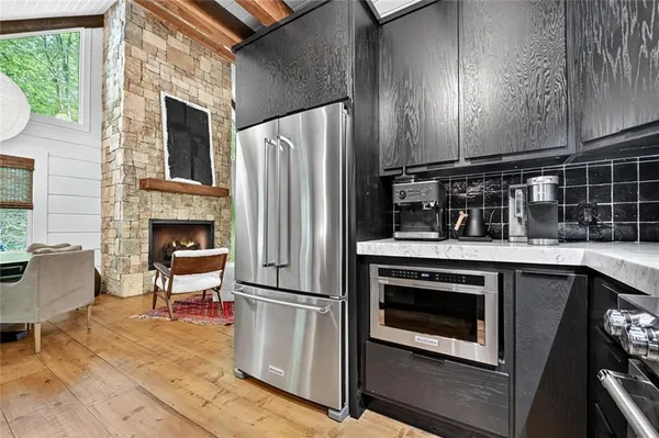 a kitchen with granite countertop a refrigerator stove and microwave