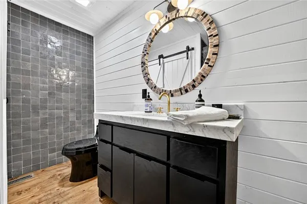 a bathroom with a sink a toilet and mirror