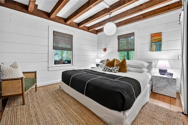 a bedroom with a bed lamp and a large window