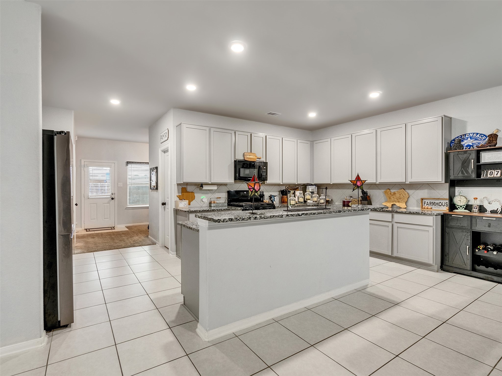 8719 Willet Street Baytown, TX 77521 - Photo 18 of 42 a kitchen with stainless steel appliances granite countertop a refrigerator and a stove top oven