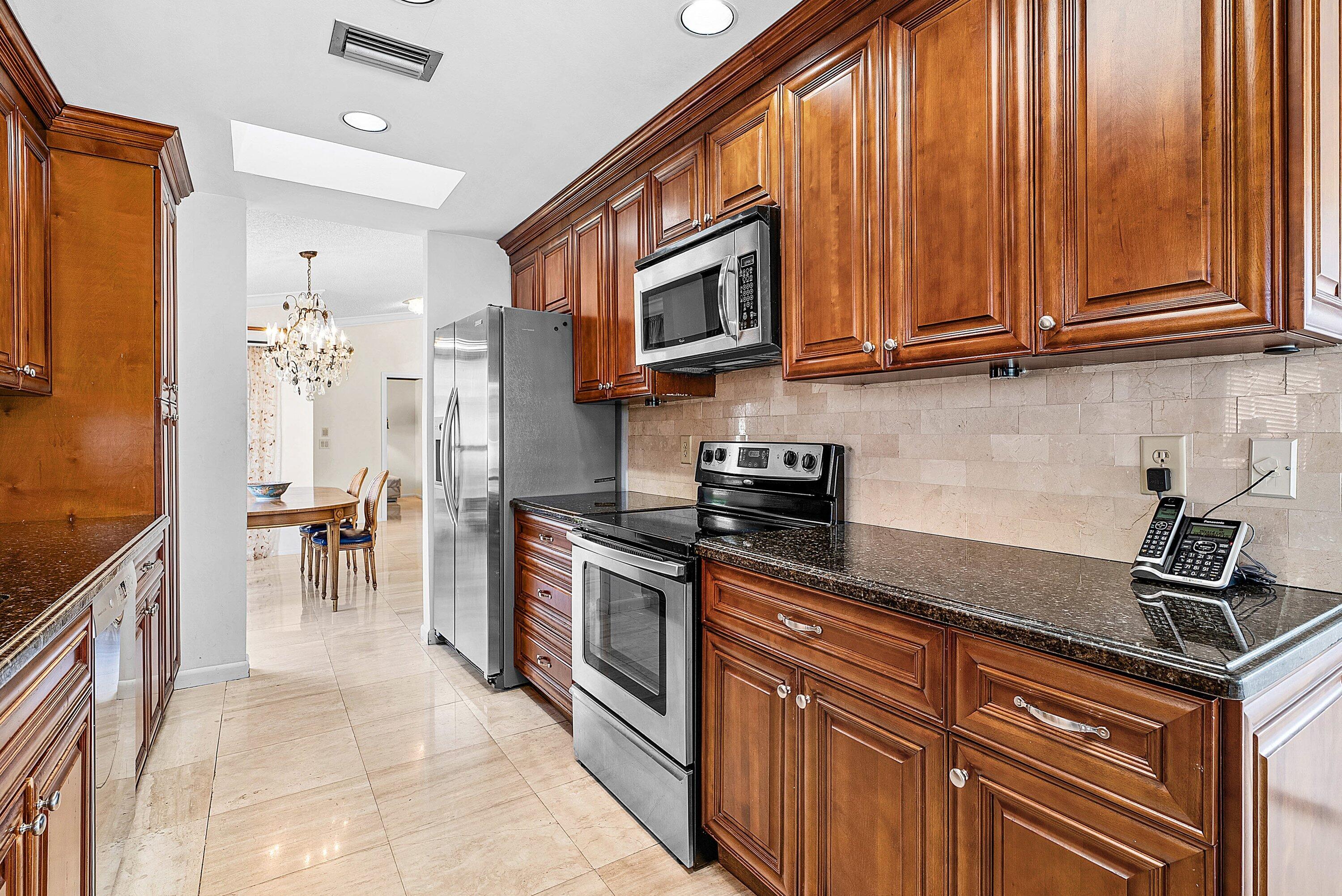 21459 Bridgeview Drive Boca Raton, FL 33428 - Photo 14 of 61 a kitchen with stainless steel appliances granite countertop a stove a sink and a microwave