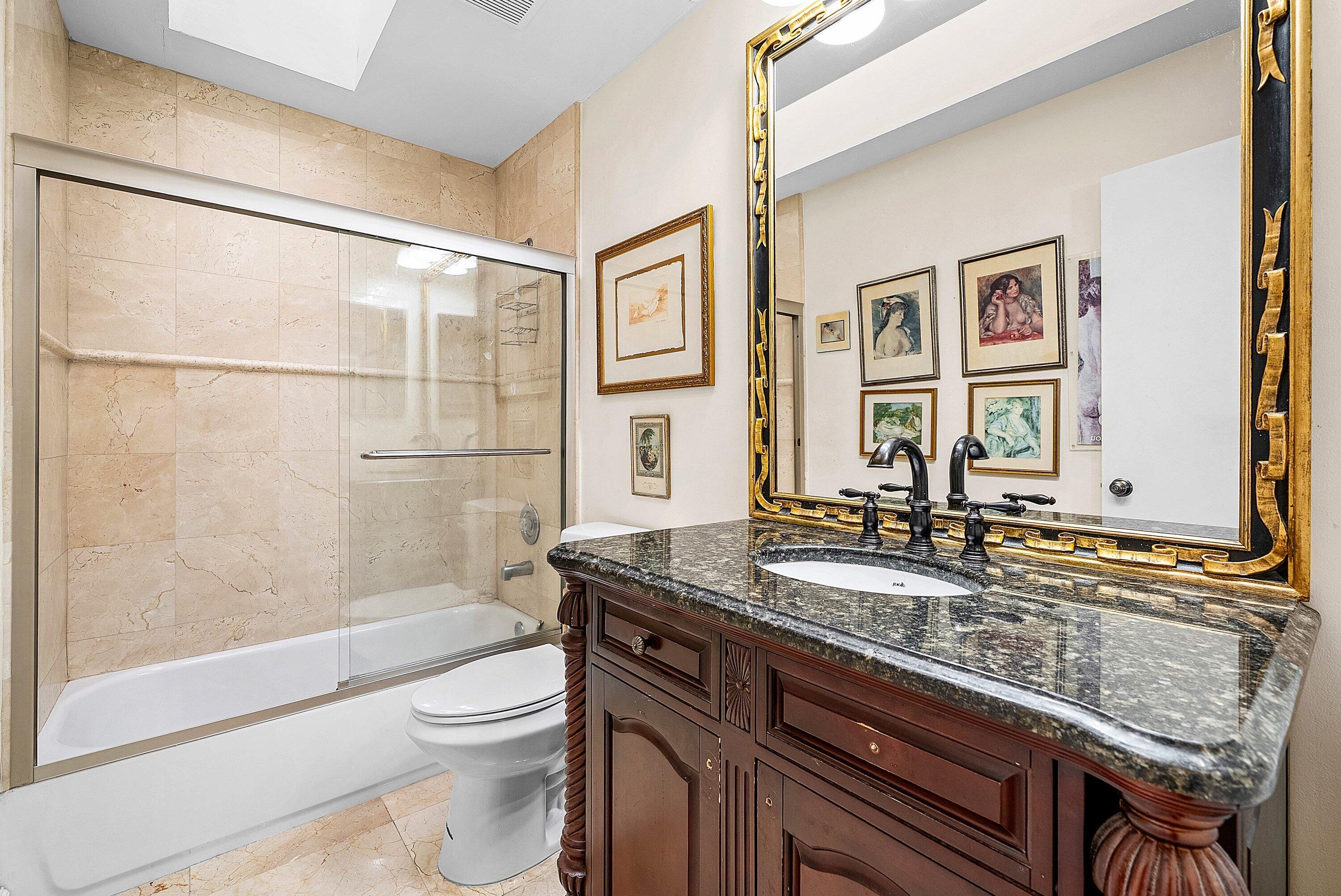 21459 Bridgeview Drive Boca Raton, FL 33428 - Photo 28 of 61 a bathroom with a granite countertop sink a toilet a mirror and shower