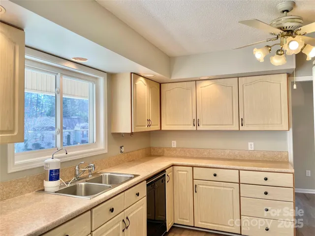 a kitchen with granite countertop white cabinets stainless steel appliances and wooden floor