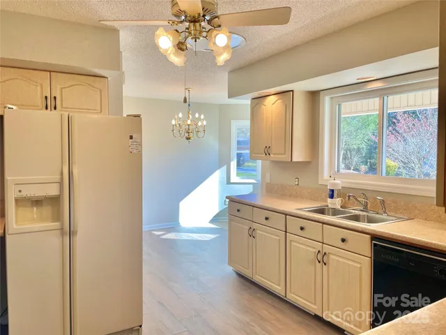 a kitchen that has a lot of white cabinets and wooden floor