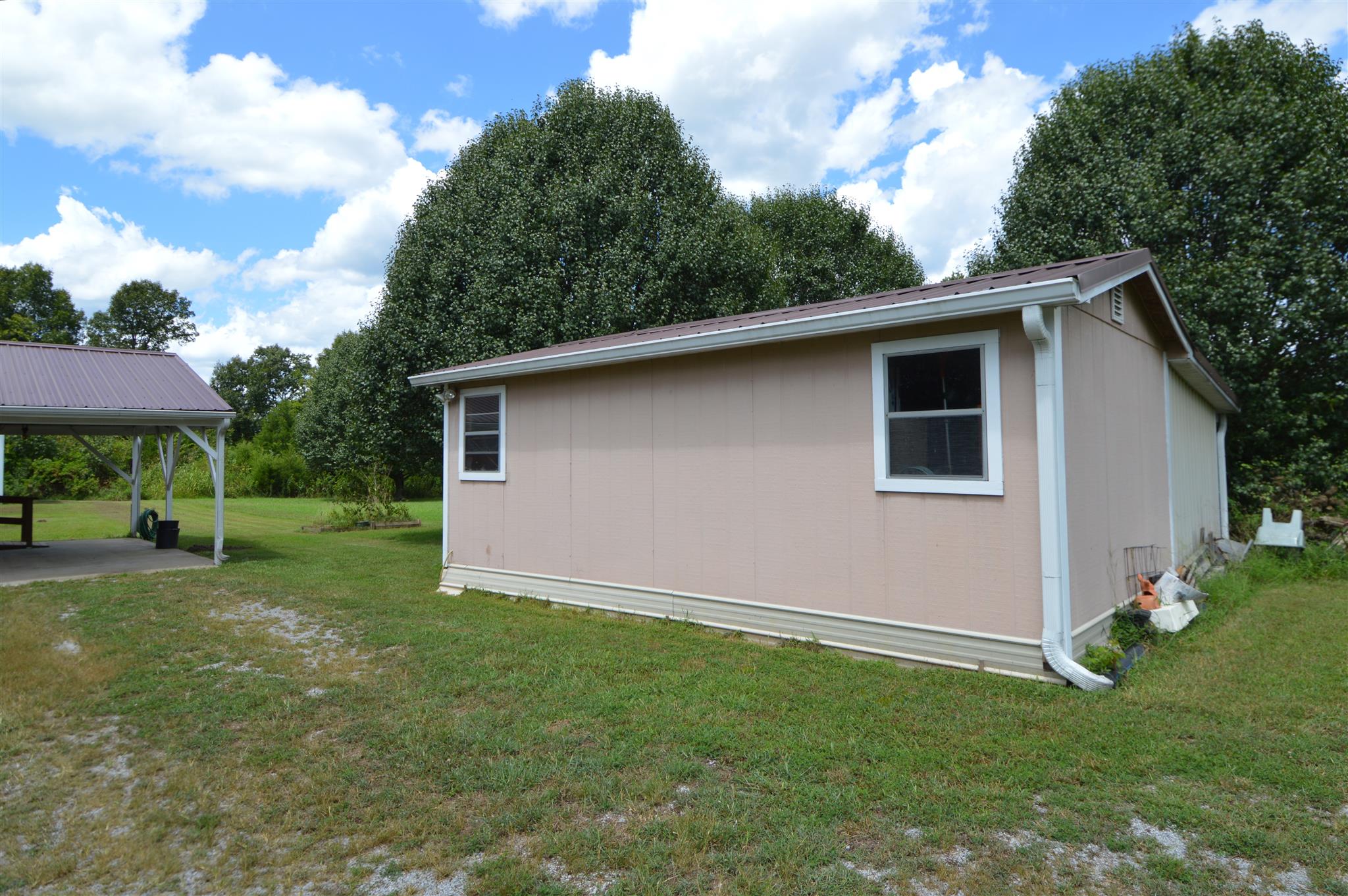 4579 Beech Log Road Lebanon, TN 37090 - Photo 21 of 30 a backyard of a house with plants and barbeque oven