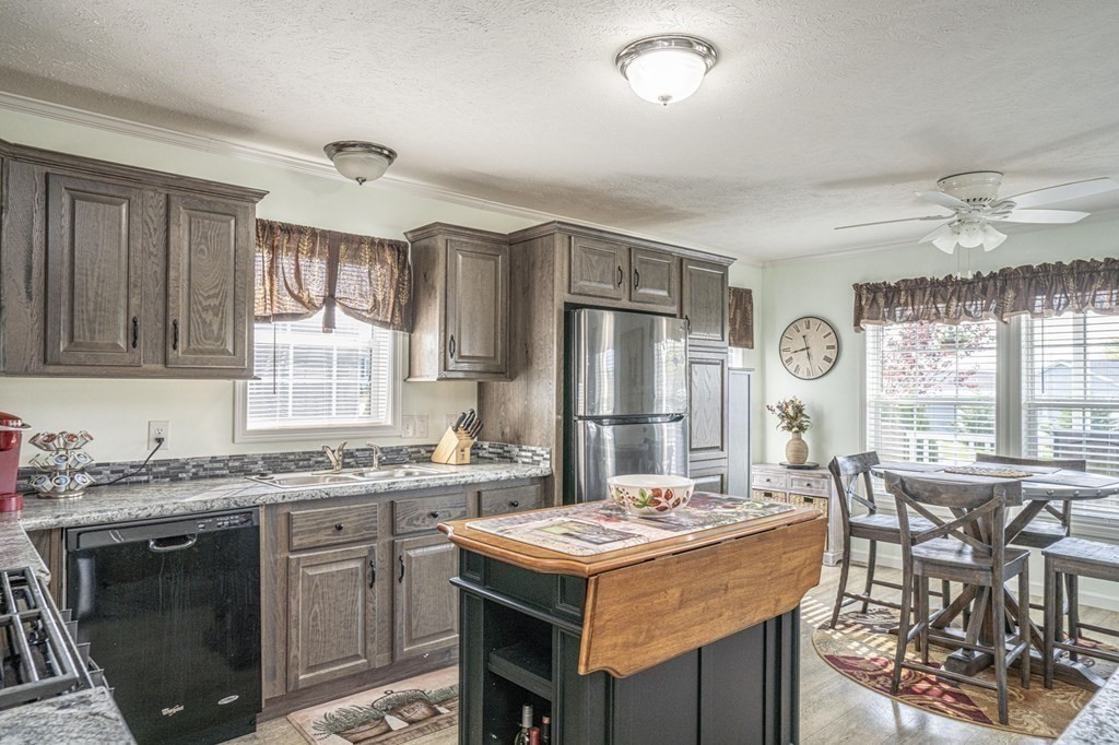 18 Linsay Drive Raynham, MA 02767 - Photo 6 of 41 a kitchen with a stove a sink a refrigerator and chairs