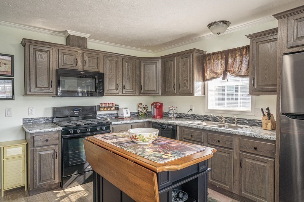 18 Linsay Drive Raynham, MA 02767 - Photo 7 of 41 a kitchen with a stove a sink and a refrigerator