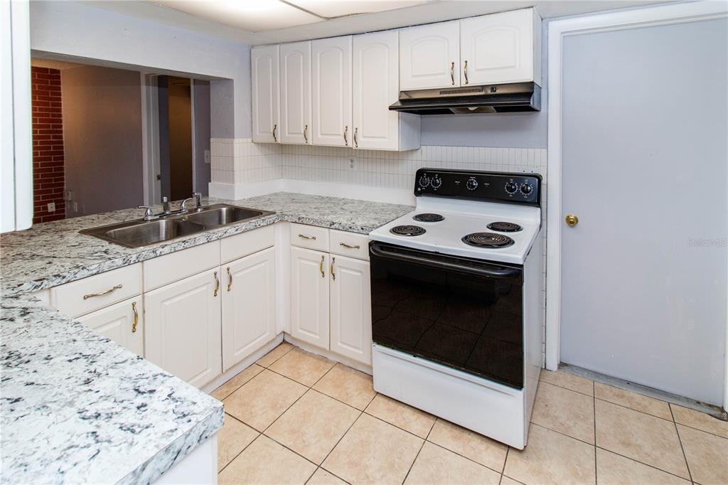 4150 Newbury Drive New Port Richey, FL 34652 - Photo 14 of 32 a kitchen with granite countertop a stove sink and cabinets