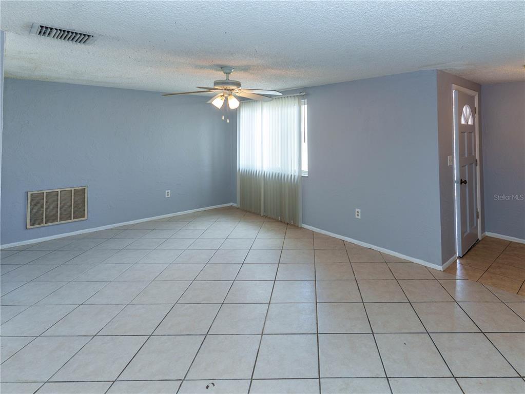 4150 Newbury Drive New Port Richey, FL 34652 - Photo 2 of 32 an empty room with windows and chandelier fan