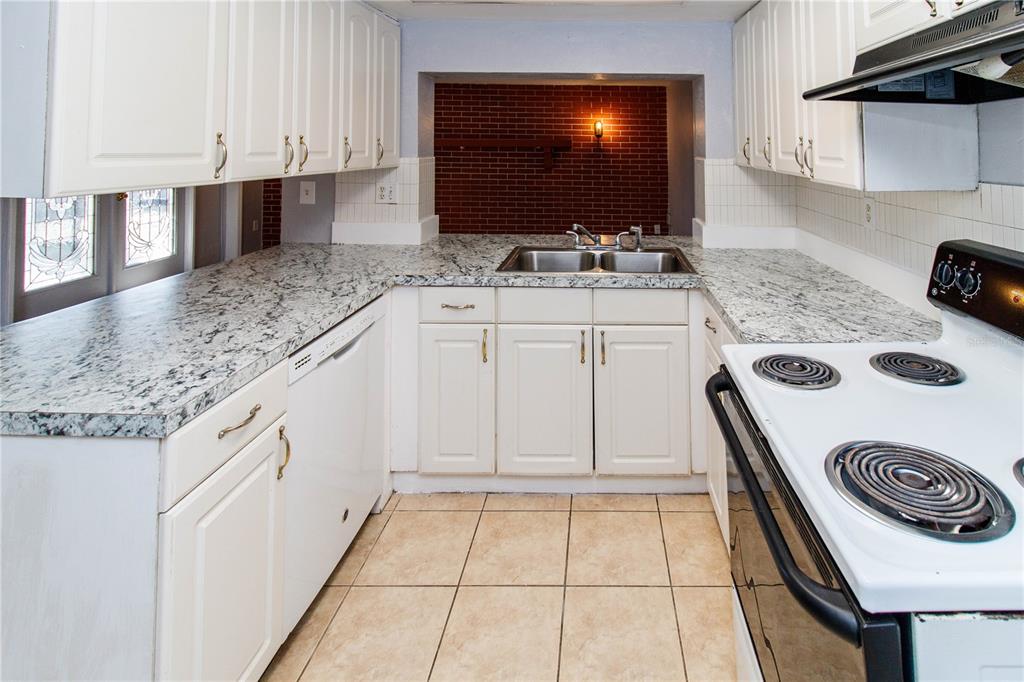 4150 Newbury Drive New Port Richey, FL 34652 - Photo 4 of 32 a kitchen with stainless steel appliances kitchen island granite countertop a sink and a stove