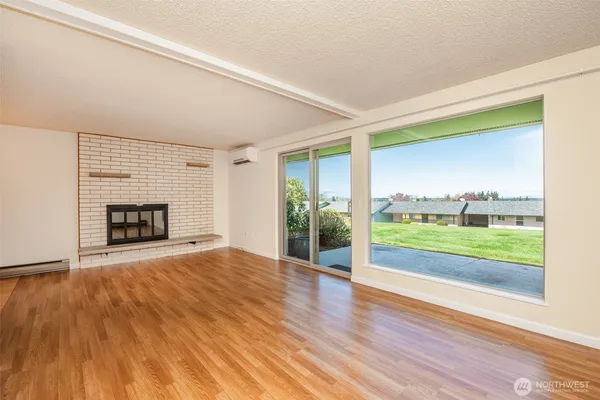 a view of an empty room with a fireplace and a window