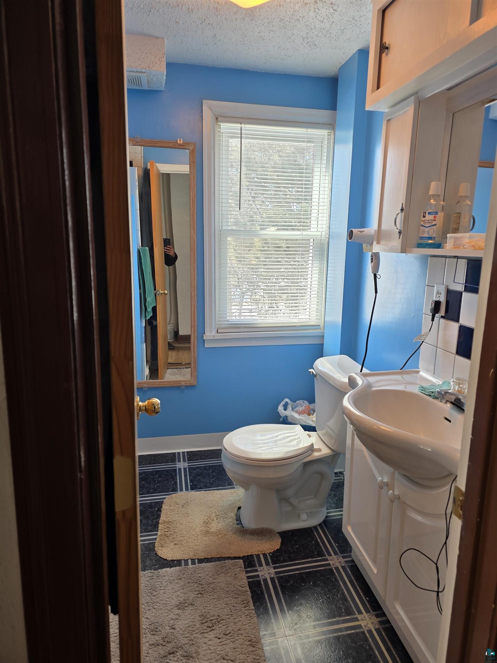 406 North Road Cloquet, MN 55720 - Photo 12 of 26 Half bath with vanity and a textured ceiling