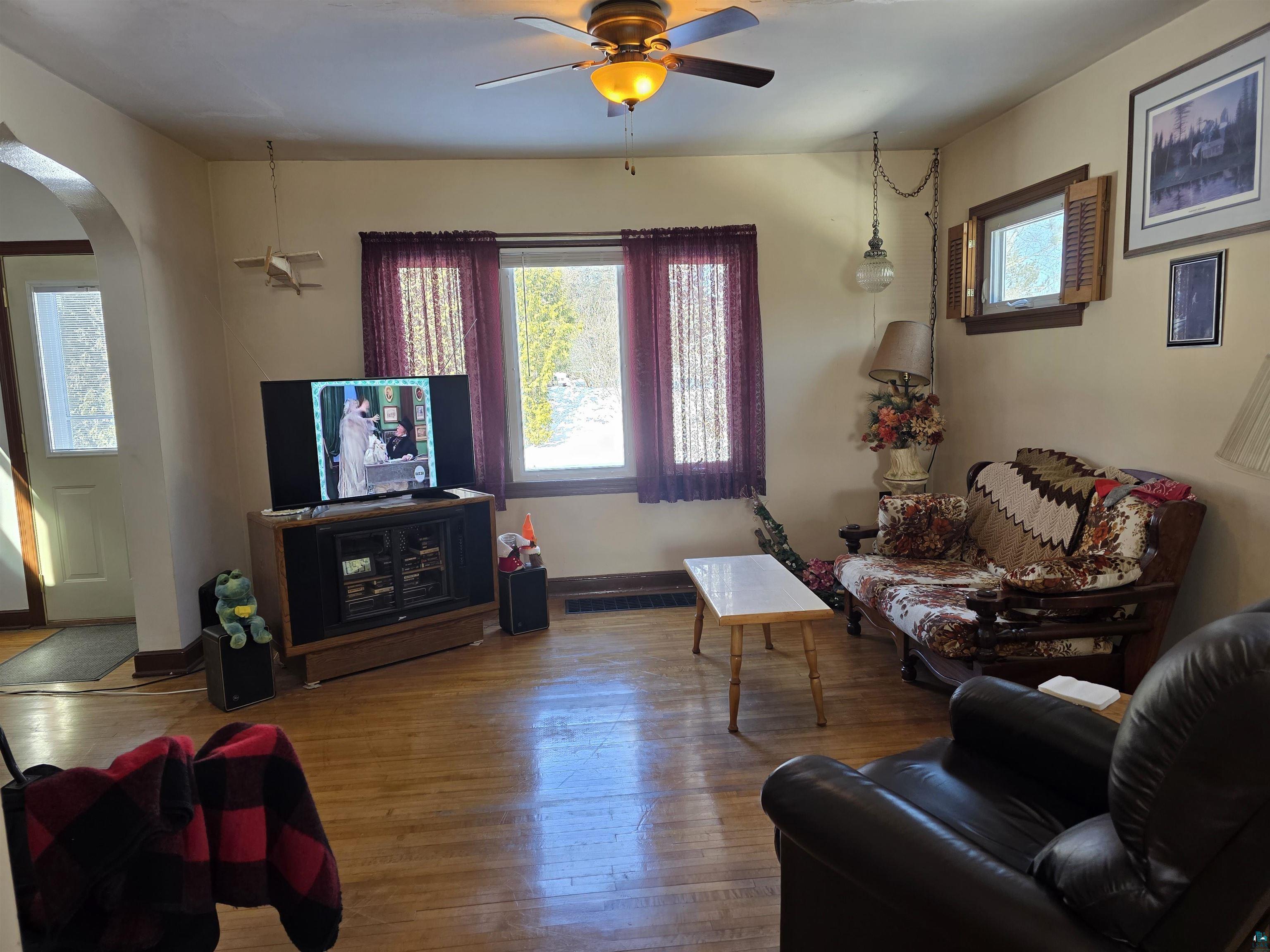 406 North Road Cloquet, MN 55720 - Photo 4 of 26 Living room featuring hardwood / wood-style flooring, a ceiling fan, and arched walkways