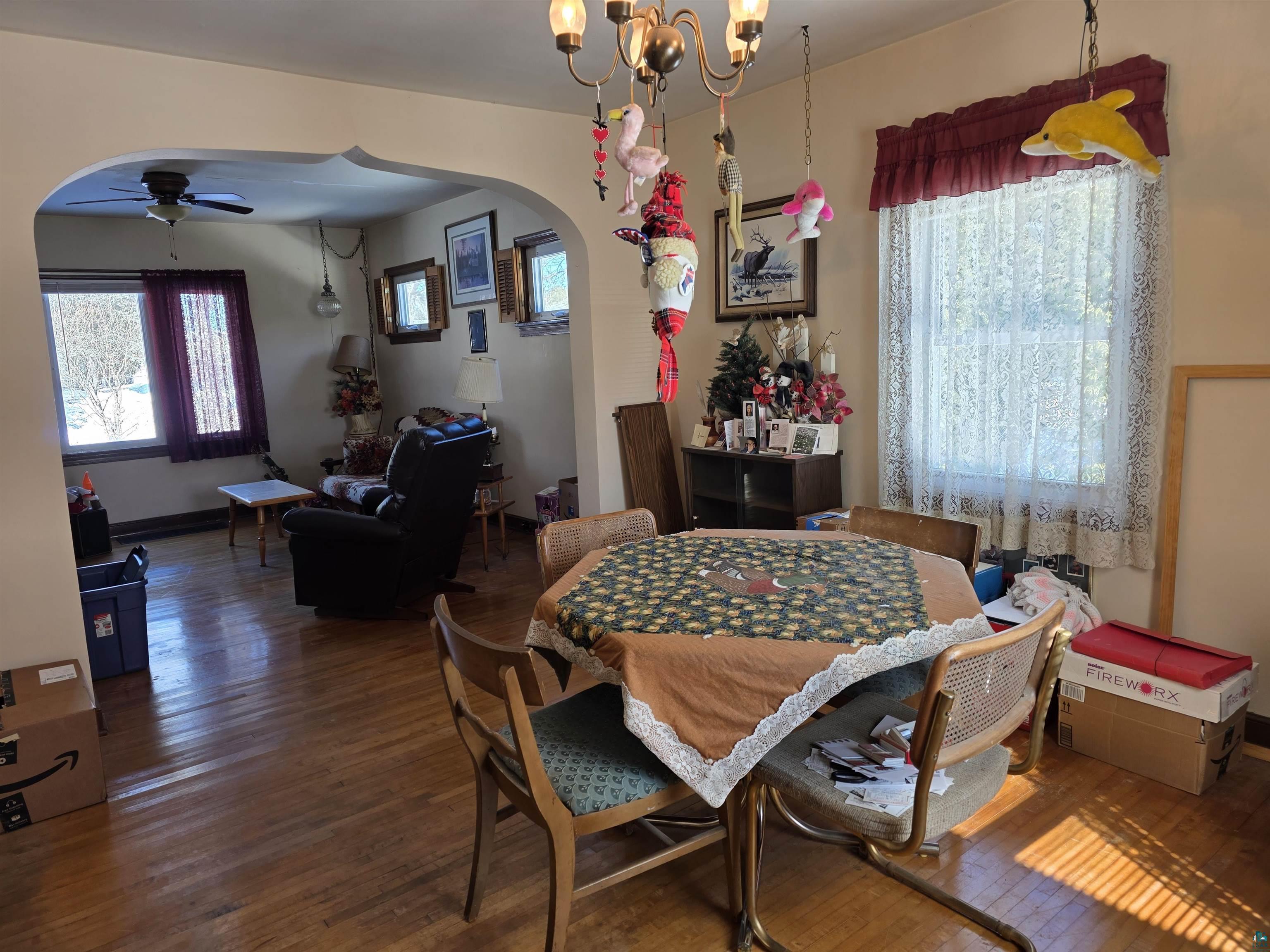 406 North Road Cloquet, MN 55720 - Photo 6 of 26 Dining space with arched walkways, hardwood / wood-style flooring, a ceiling fan, and suspended lighting