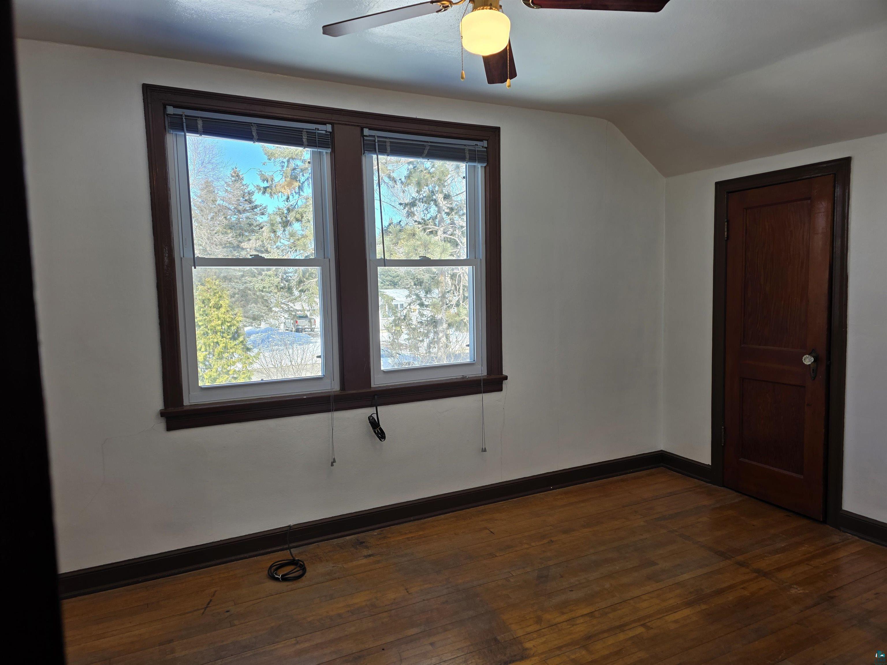 406 North Road Cloquet, MN 55720 - Photo 9 of 26 Additional living space featuring dark wood-type flooring, vaulted ceiling, and a ceiling fan