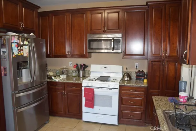 a kitchen with stainless steel appliances granite countertop a refrigerator stove and sink