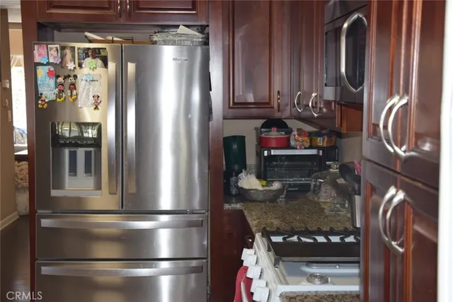 a kitchen with stainless steel appliances granite countertop a refrigerator and a stove