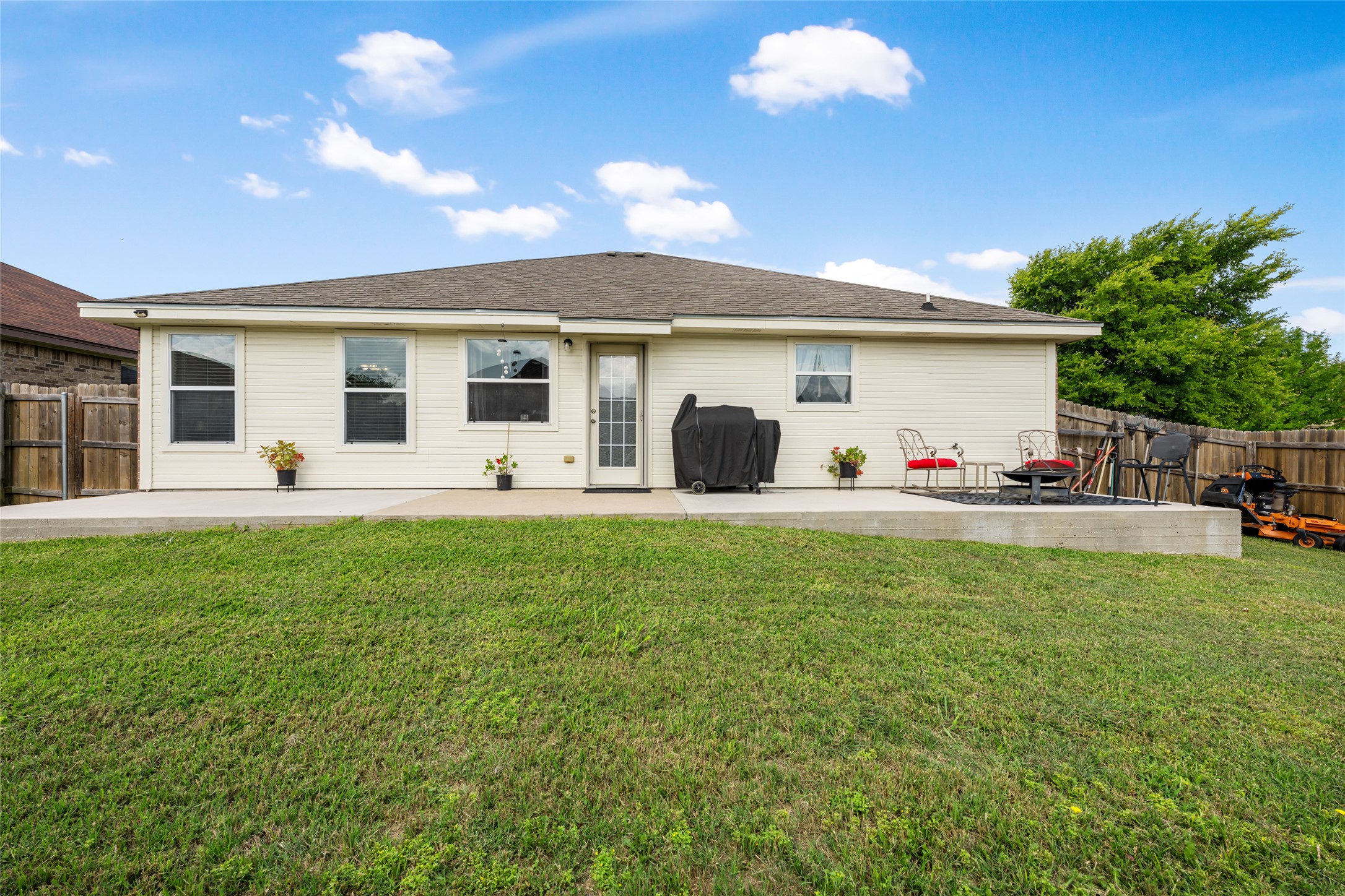 144 Calcite Lane Jarrell, TX 76537 - Photo 34 of 38 A spacious lawn unfolds from a concrete patio, perfect for outdoor enjoyment.