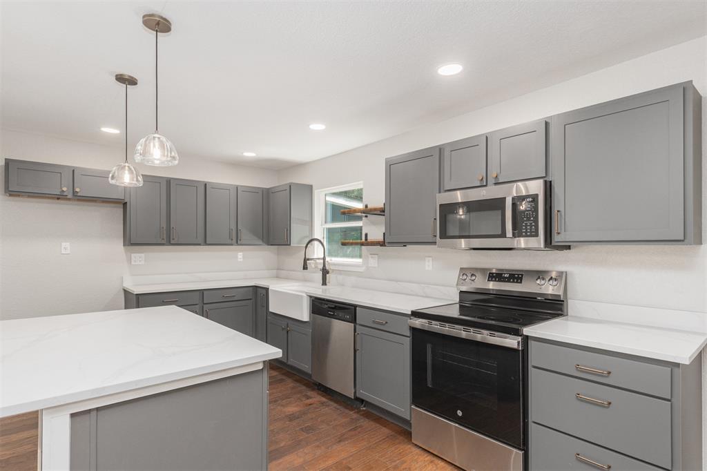 1024 Tower Street Canton, TX 75103 - Photo 6 of 27 a kitchen with a sink a stove a microwave and wooden floor