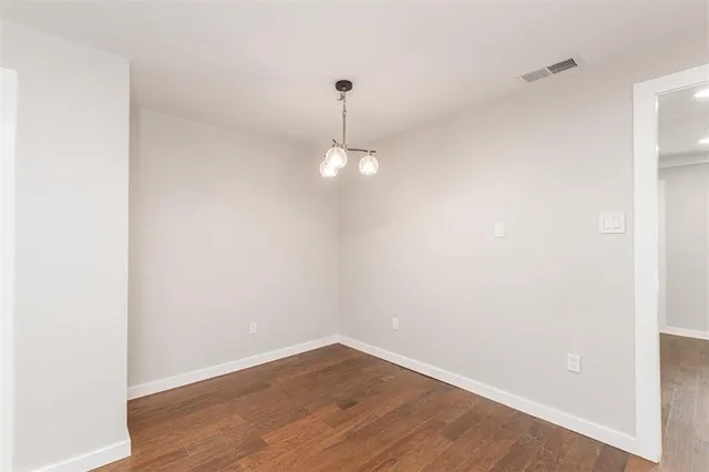 a view of a room with wooden floor and ceiling fan