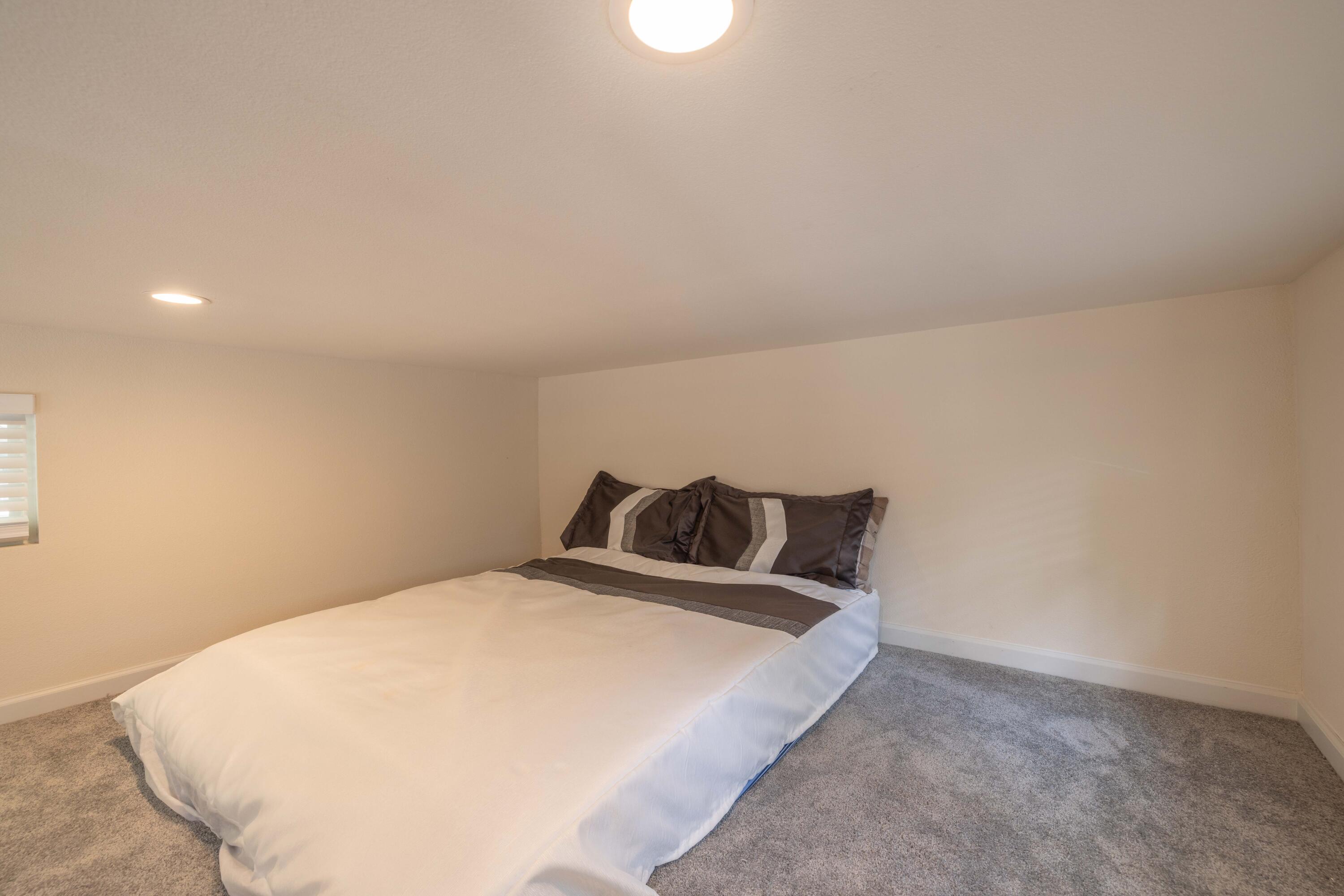 547 Alden Road, Unit RV4 Big Bear Lake, CA 92315 - Photo 38 of 38 a bed sitting in a bedroom next to a lamp