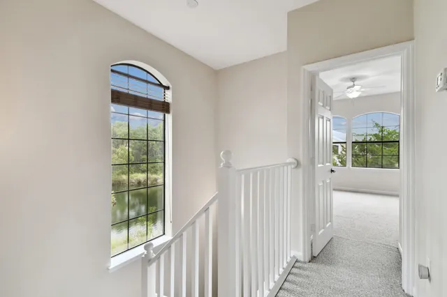 an empty room with windows and ceiling fan