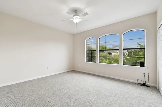 an empty room with closet and a ceiling fan