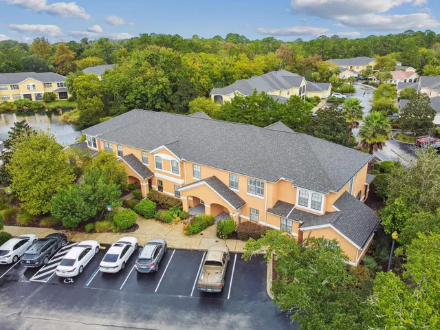 an aerial view of residential houses with outdoor space and trees