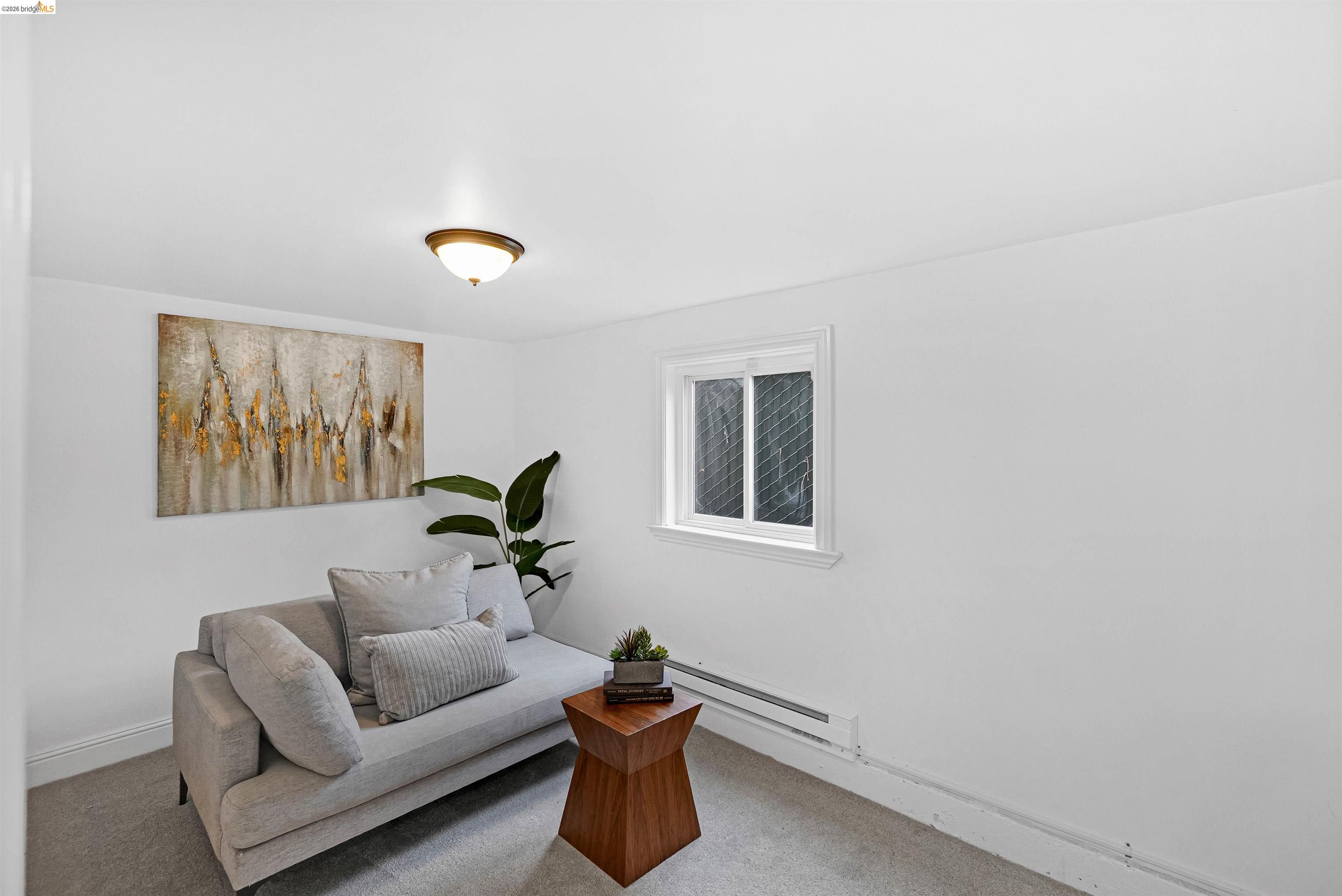 1812 Woolsey Street Berkeley, CA 94703 - Photo 38 of 48 White walls with a single window, carpeted flooring, and a flush-mount ceiling light fixture