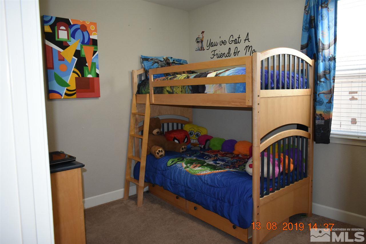 10836 Walnut Ridge Drive Reno, NV 89521 - Photo 22 of 25 a bedroom with a baby crib toys and dresser