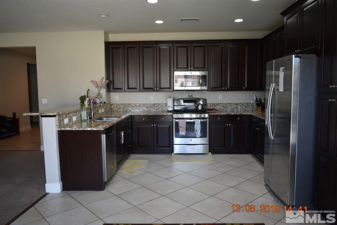10836 Walnut Ridge Drive Reno, NV 89521 - Photo 4 of 25 a kitchen with stainless steel appliances granite countertop a stove a sink dishwasher and a refrigerator