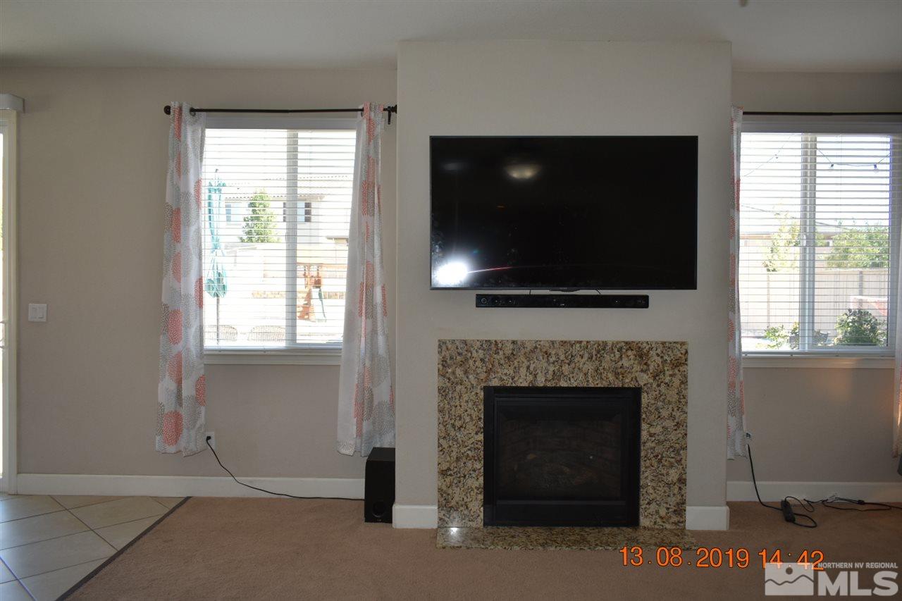 10836 Walnut Ridge Drive Reno, NV 89521 - Photo 7 of 25 a living room with a fireplace and a flat screen tv