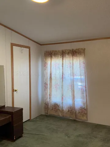 en empty room with windows and chandelier fan