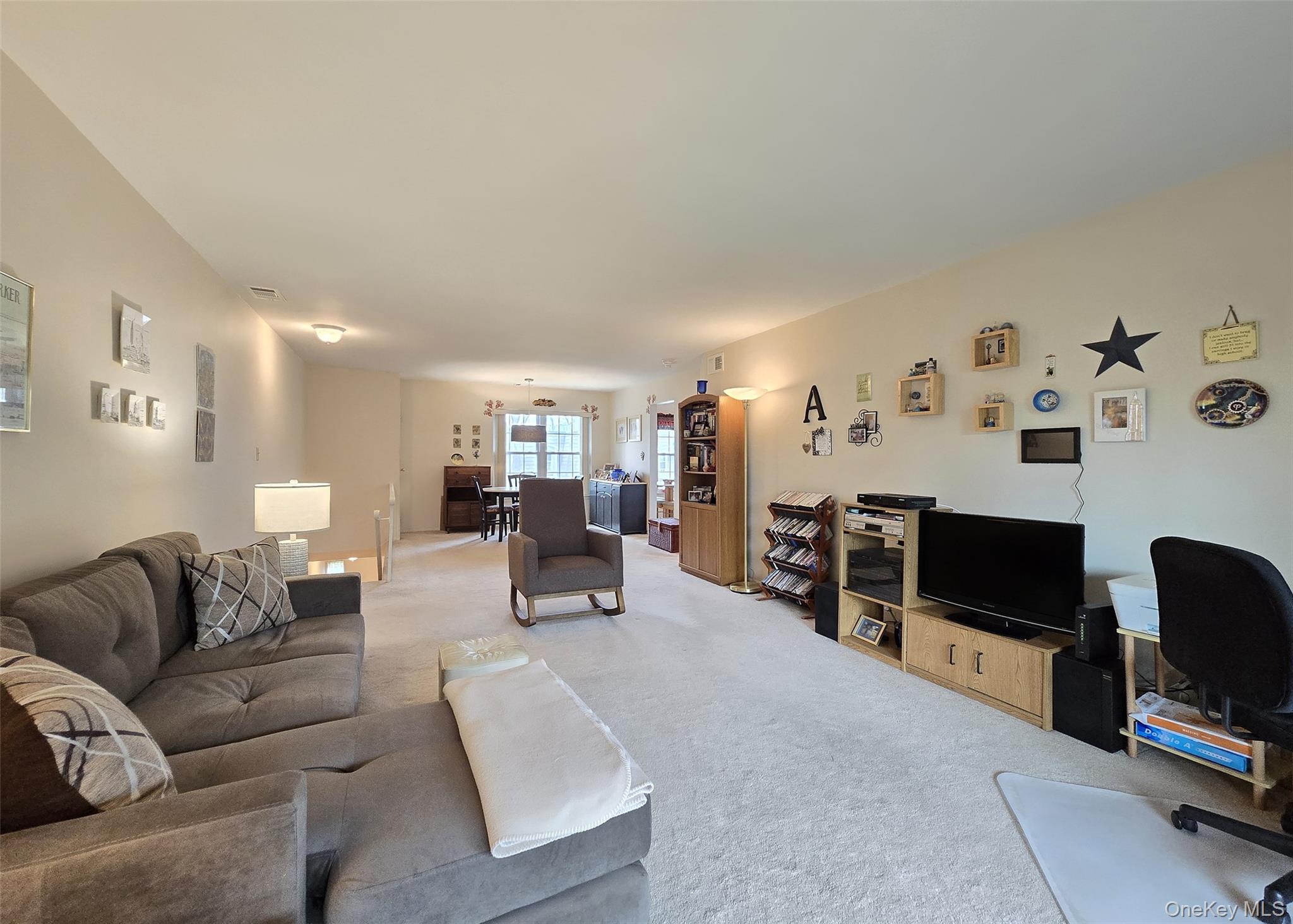 655 Middle Country Road, Unit 22E2 Coram, NY 11727 - Photo 5 of 16 a living room with furniture and a flat screen tv
