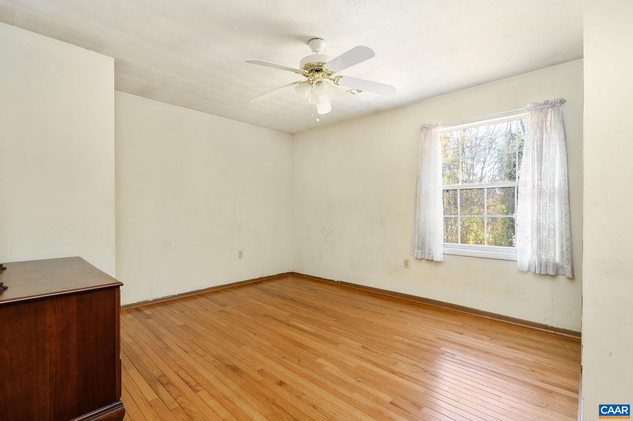 202 Hartmans Mill Road Charlottesville, VA 22902 - Photo 10 of 27 an empty room with wooden floor fan and windows