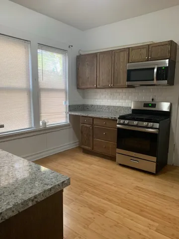 a kitchen with stainless steel appliances granite countertop a stove a microwave and a sink