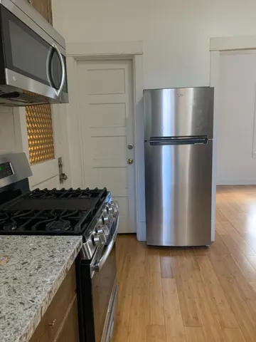 a kitchen with a refrigerator and a stove top oven