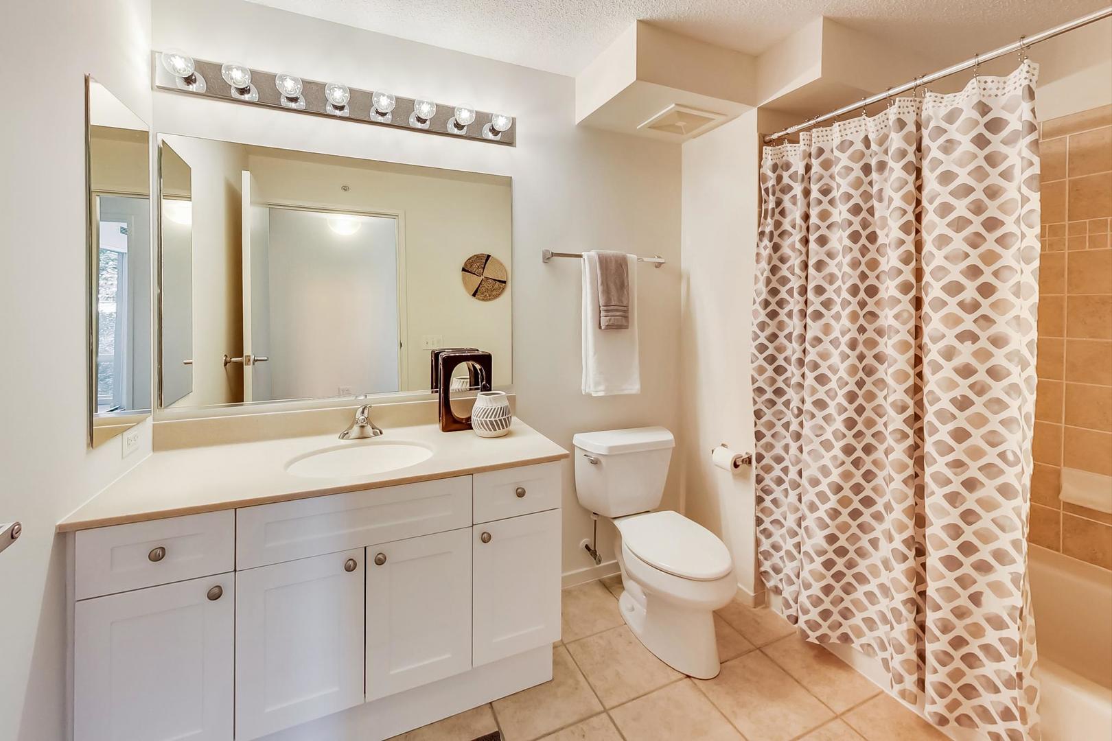 800 Elgin Road, Unit 702 Evanston, IL 60201 - Photo 13 of 16 a bathroom with a double vanity sink mirror and toilet