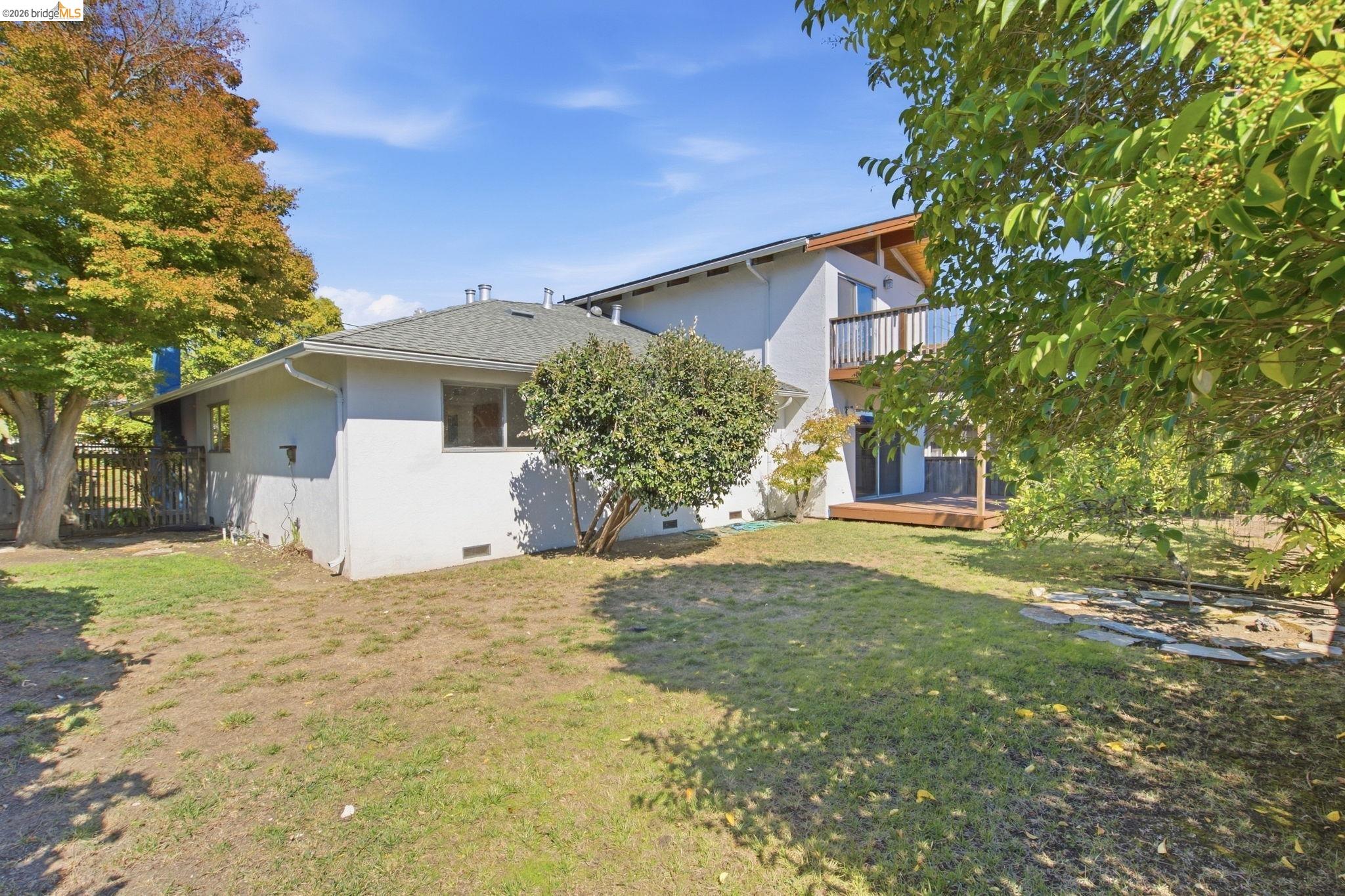 4522 Santa Rita Road El Sobrante, CA 94803 - Photo 47 of 58 Rear exterior with an upper-level balcony, a lower-level wood deck, and a fenced perimeter