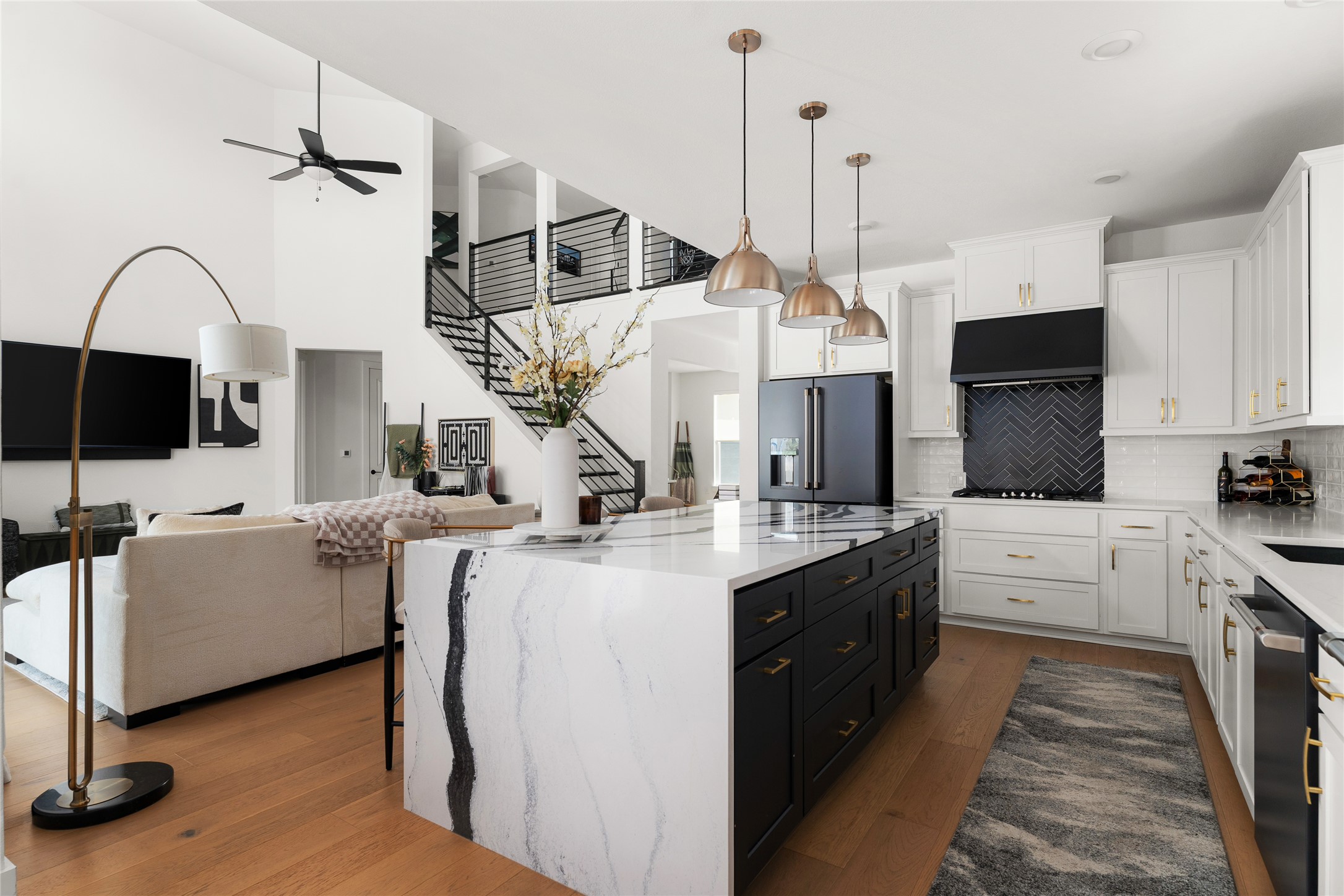 7917 Edmondson Bend Austin, TX 78744 - Photo 7 of 24 Open-concept kitchen featuring a waterfall island, black cabinetry, white countertops, and stainless steel appliances