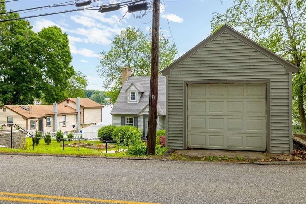 5 West Sutton Road Sutton, MA 01590 - Photo 34 of 36 a front view of a house with a garage and outdoor seating