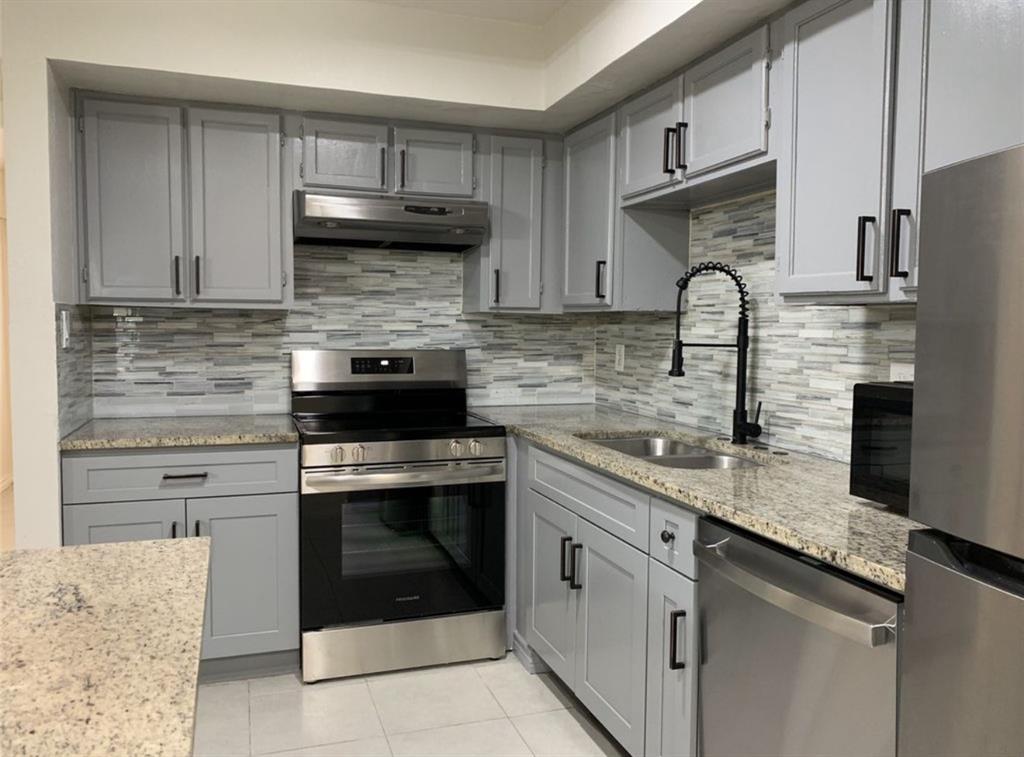 9803 Walnut Street, Unit 107 Dallas, TX 75243 - Photo 2 of 10 a kitchen with granite countertop a sink stainless steel appliances and cabinets